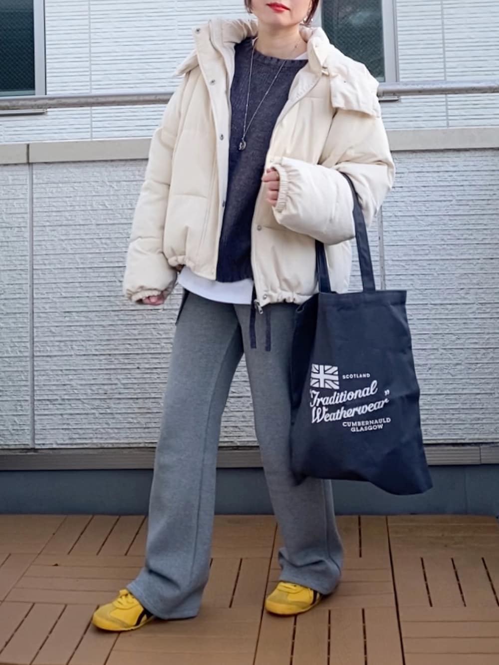 ホワイト系のダウンジャケット/コート、グレー系のニット/セーター、グレー系のその他パンツを着用したレディースの冬コーディネートの2枚目の写真