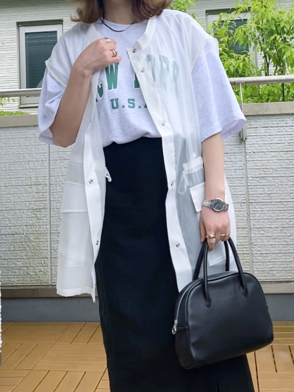 ホワイト系のベスト、ホワイト系のTシャツ/カットソー、ブラック系のスカートを着用したレディースの夏コーディネートの2枚目の写真