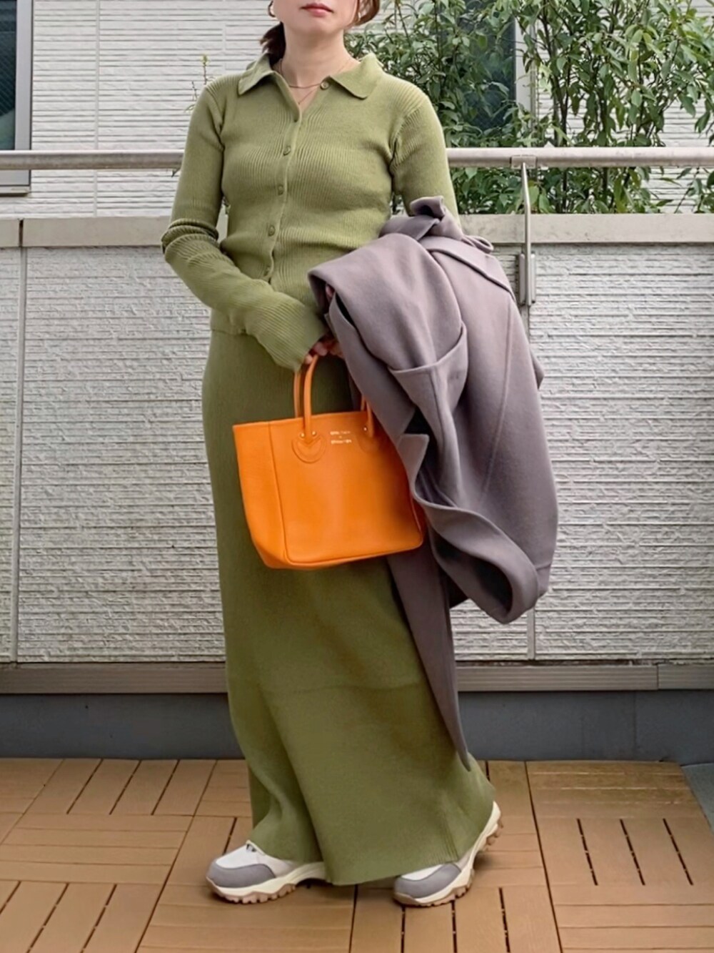 ブラウン系のチェスターコート、グリーン系のカーディガン/ボレロ、グリーン系のスカートを着用したレディースの秋コーディネートの5枚目の写真