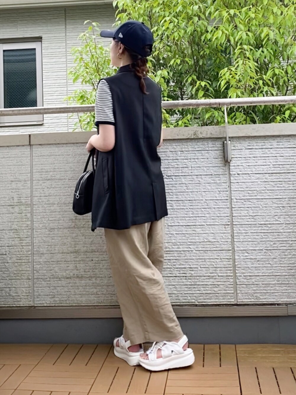 ホワイト系のTシャツ/カットソー、ブラック系のベスト、ベージュ系のその他パンツを着用したレディースの夏コーディネートの3枚目の写真