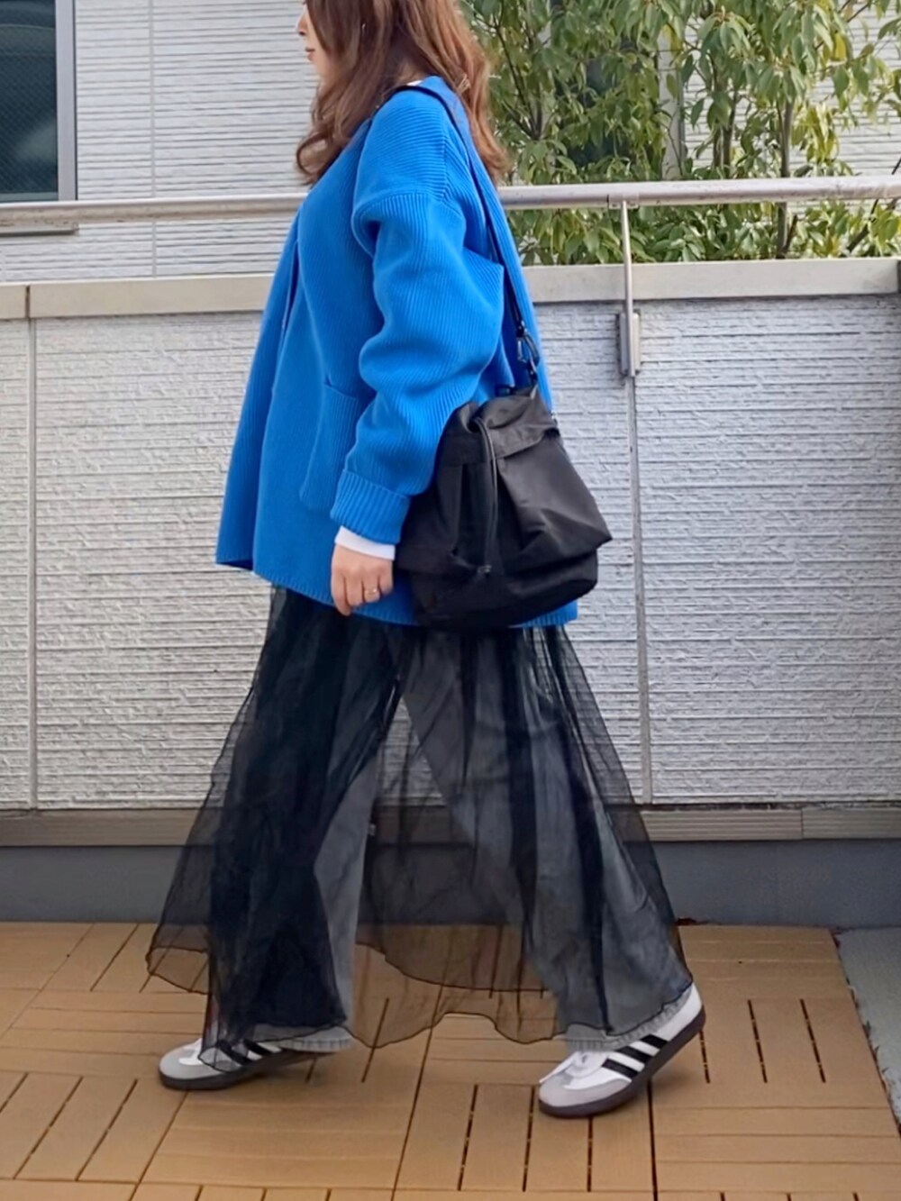 ブルー系のカーディガン/ボレロ、ホワイト系のTシャツ/カットソー、ブラック系のワンピースを着用したレディースの冬コーディネートの3枚目の写真