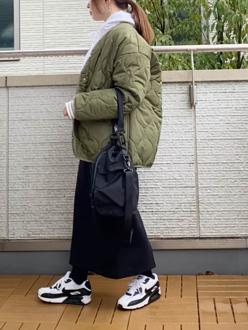 その他のTシャツ/カットソー、ブラック系のスカート、ブラック系のショルダーバッグを着用したレディースの冬コーディネートの2枚目の写真