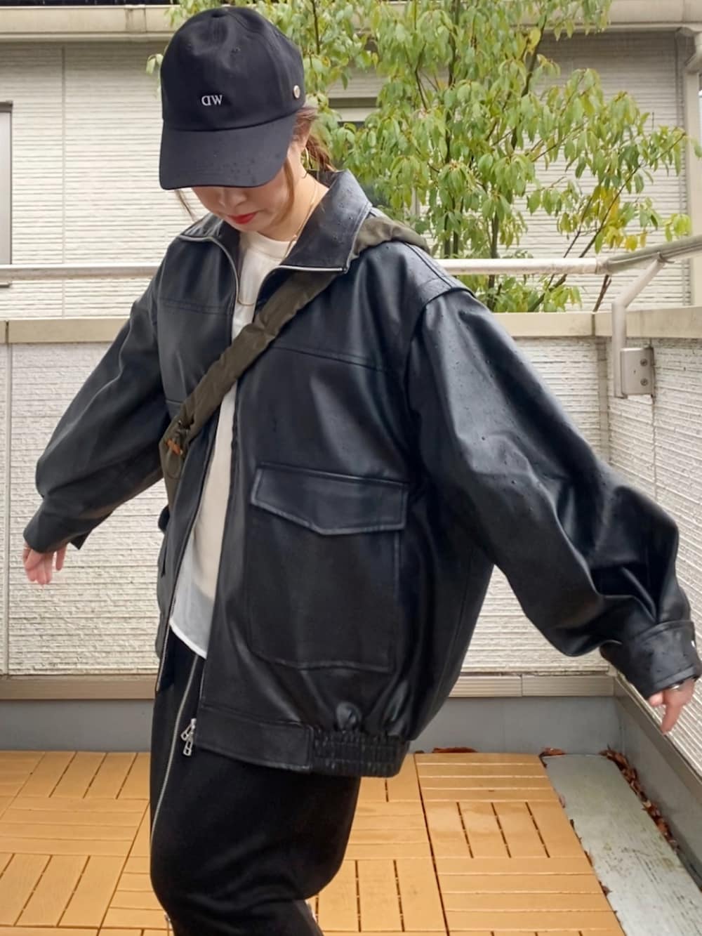 ブラック系のライダースジャケット、ホワイト系のスウェット、ブラック系のスカートを着用したレディースの春コーディネートの5枚目の写真