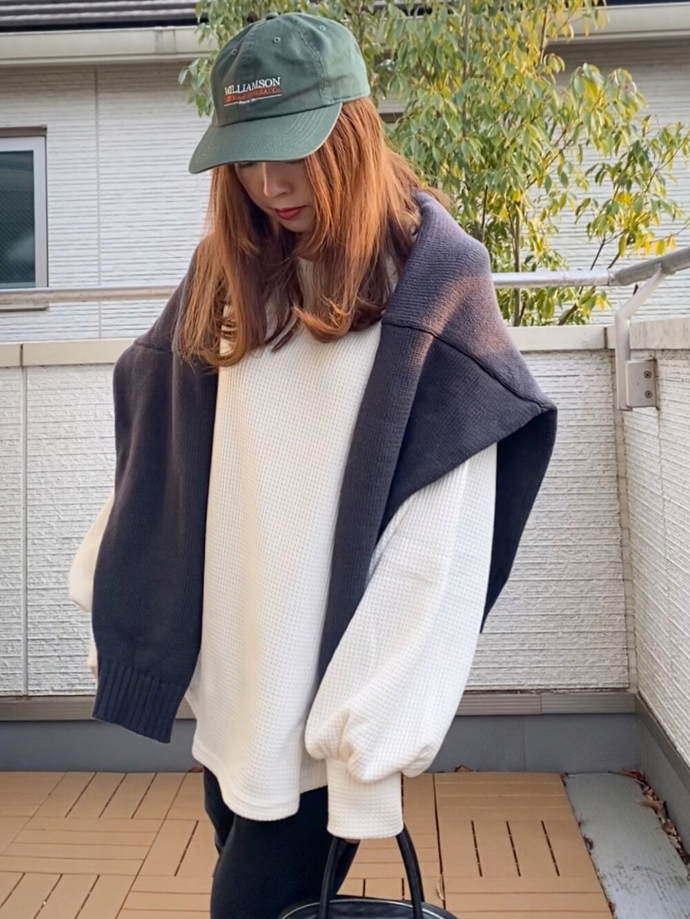 ホワイト系のスウェット、グレー系のニット/セーター、ブラック系のその他パンツを着用したレディースの冬コーディネートの4枚目の写真