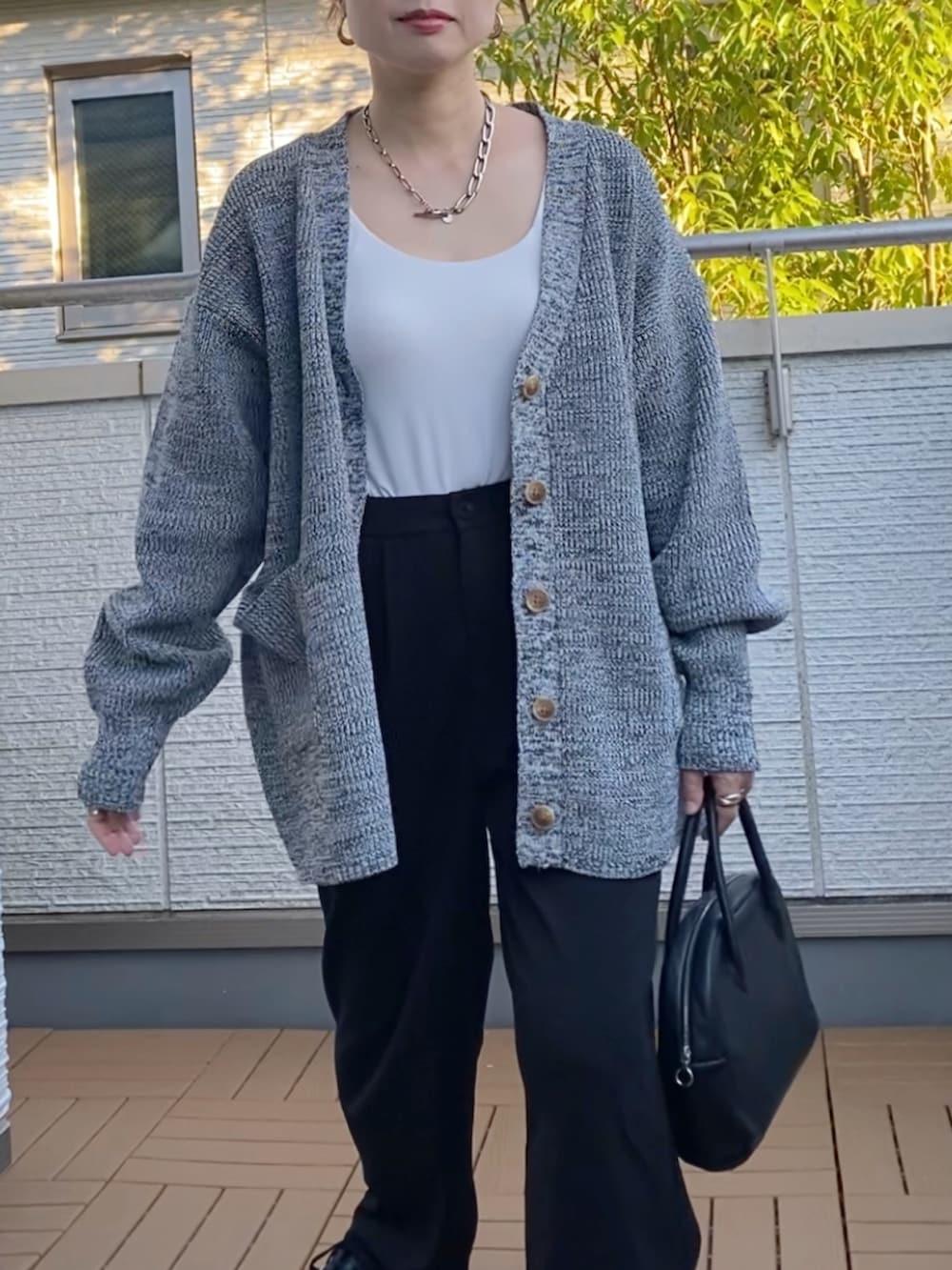 グレー系のカーディガン/ボレロ、ブラック系のショルダーバッグ、ブラック系のスニーカーを着用したレディースの秋コーディネートの3枚目の写真