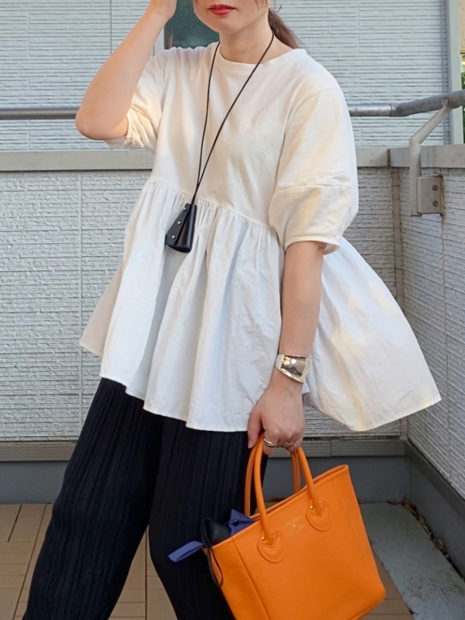 ホワイト系のTシャツ/カットソー、ブラック系のその他パンツ、オレンジ系のトートバッグを着用したレディースの夏コーディネートの5枚目の写真