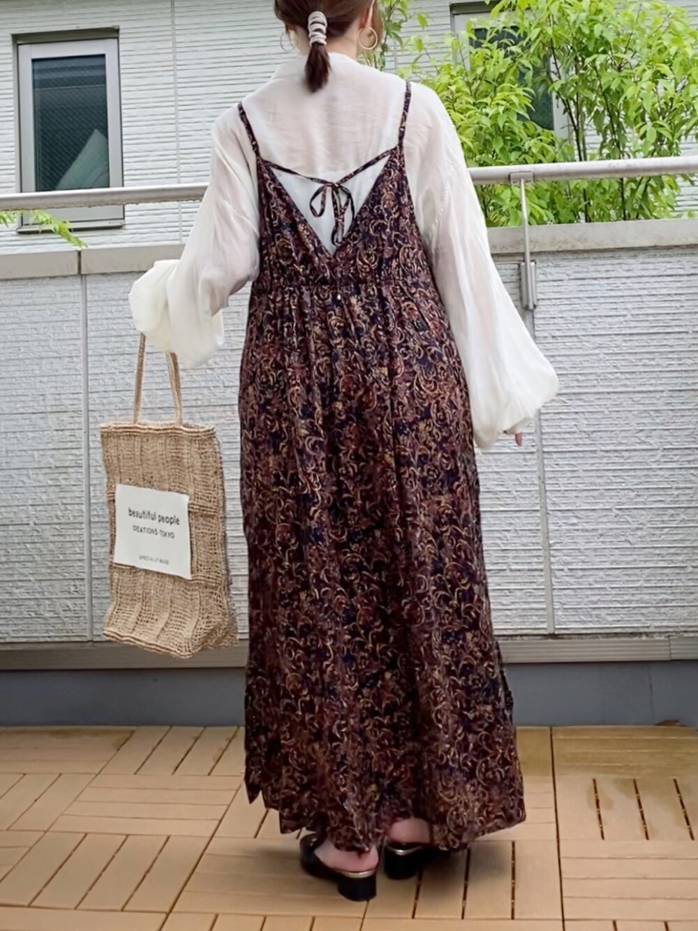 ブラック系のワンピース、ホワイト系のシャツ/ブラウス、ベージュ系のバッグを着用したレディースの春コーディネートの2枚目の写真