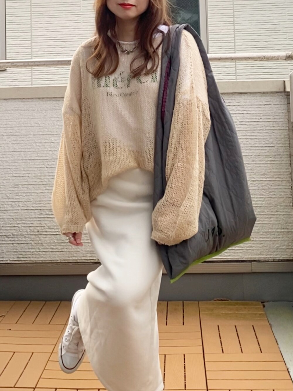 ベージュ系のニット/セーター、ホワイト系のスカート、グレー系のトートバッグを着用したレディースの秋コーディネートの4枚目の写真