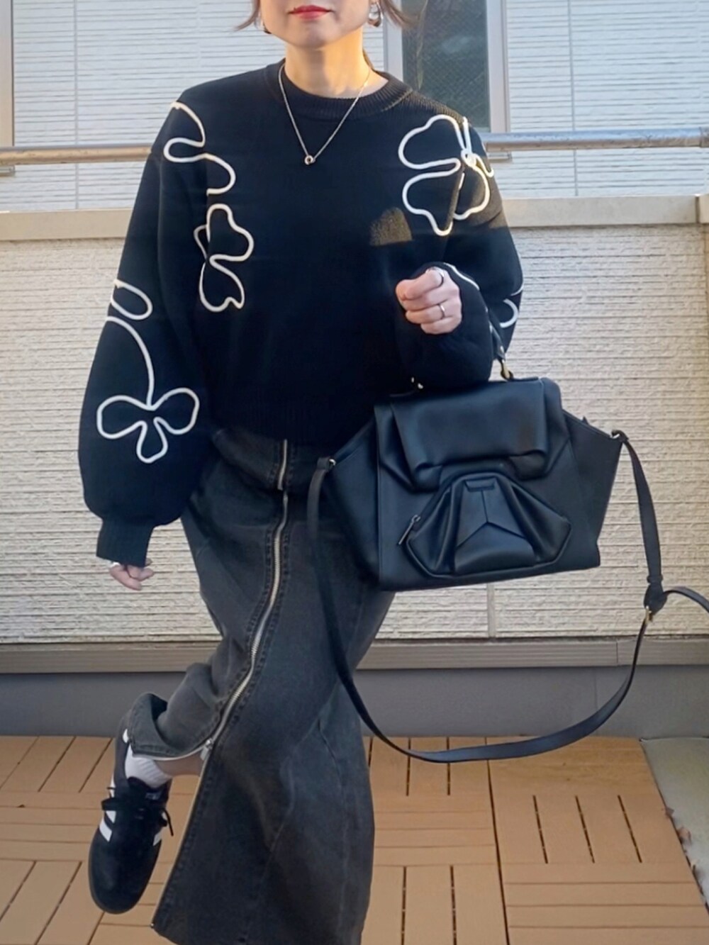 ブラック系のニット/セーター、ブラック系のブルゾン、ブラック系のスカートを着用したレディースの冬コーディネートの5枚目の写真