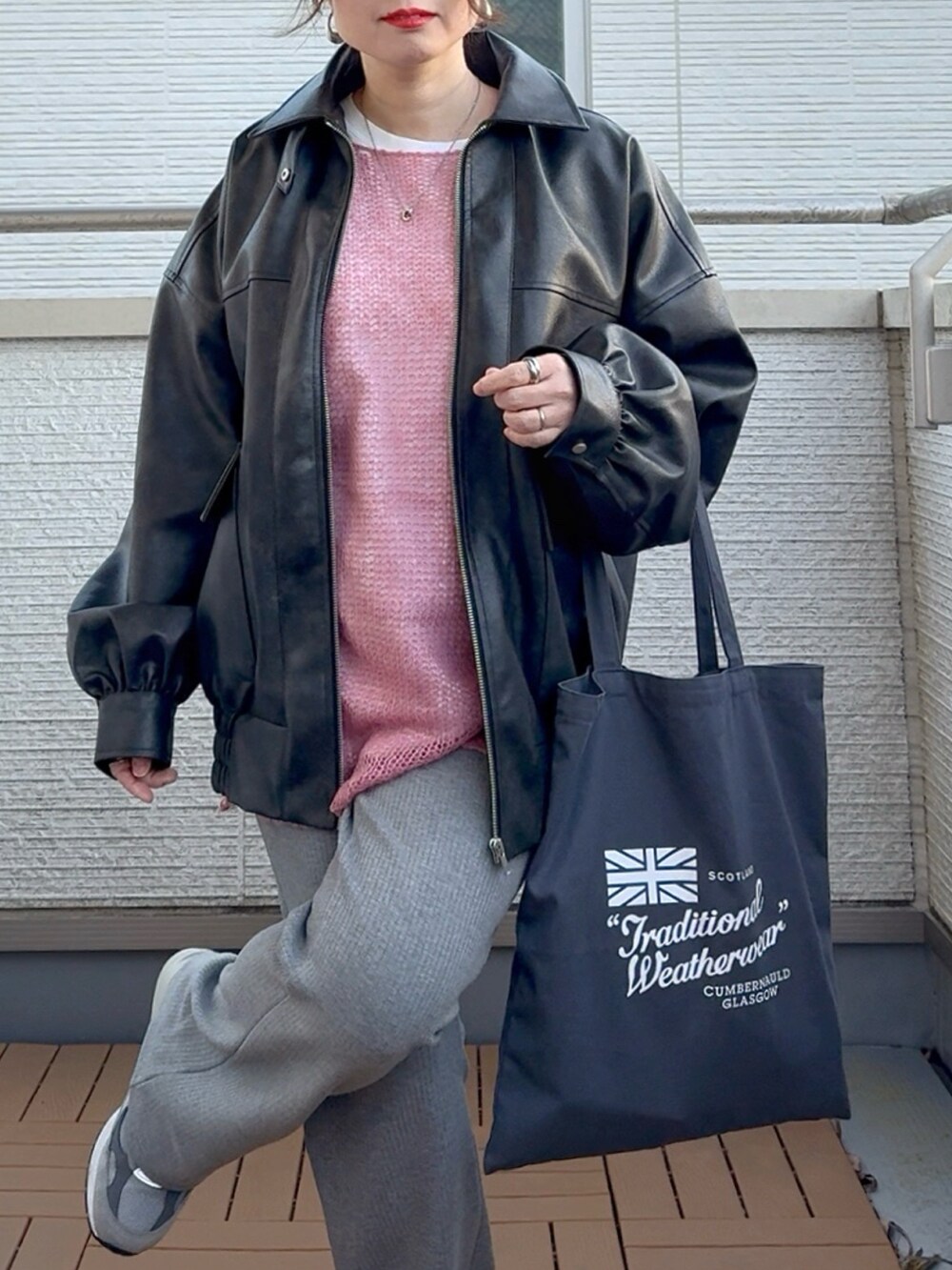 ブラック系のブルゾン、ピンク系のニット/セーター、グレー系のその他パンツを着用したレディースの冬コーディネートの4枚目の写真