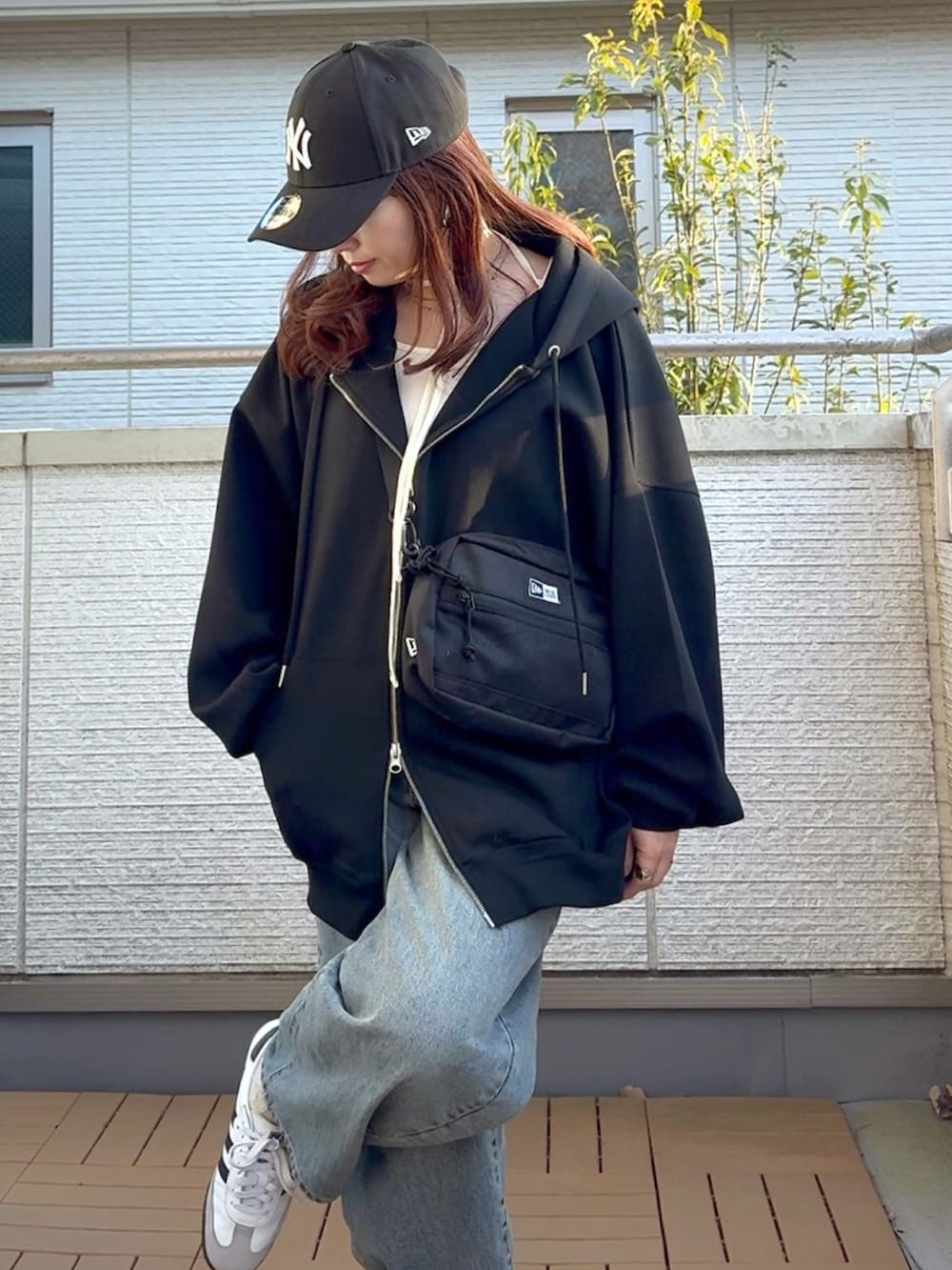 ブラック系のパーカー、ホワイト系のTシャツ/カットソー、ブラック系のショルダーバッグを着用したレディースの春コーディネートの4枚目の写真