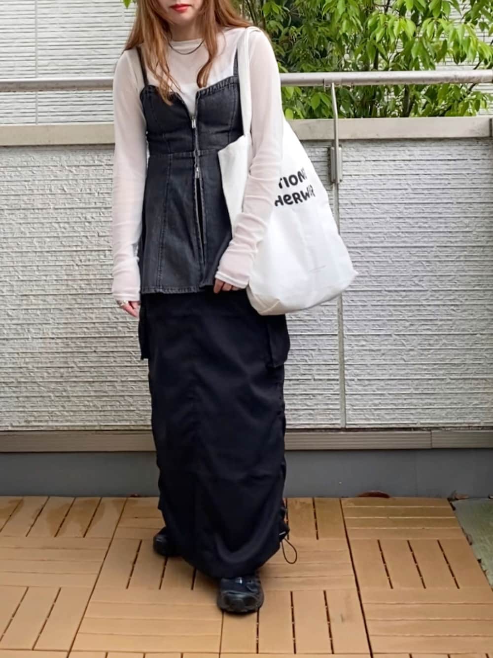 ホワイト系のTシャツ/カットソー、ブラック系のベスト、ブラック系のスカートを着用したレディースの春コーディネートの3枚目の写真