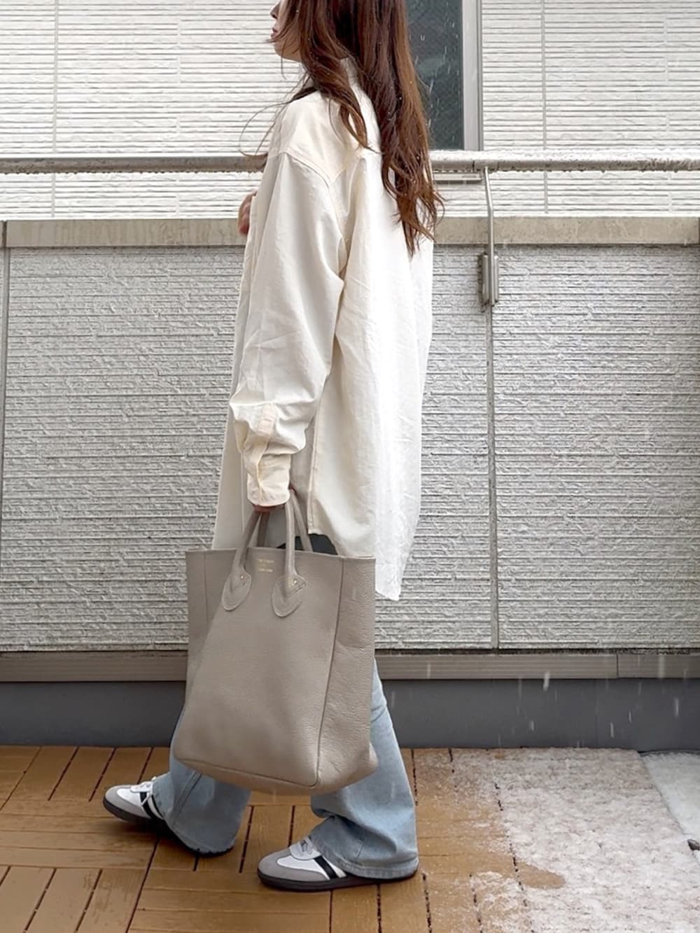 ホワイト系のシャツ/ブラウス、ベージュ系のTシャツ/カットソー、ブルー系のデニムパンツを着用したレディースの春コーディネートの4枚目の写真