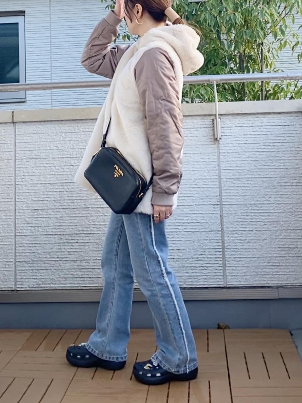 グレー系のニット/セーター、ブルー系のデニムパンツ、ホワイト系のトートバッグを着用したレディースの秋コーディネートの4枚目の写真