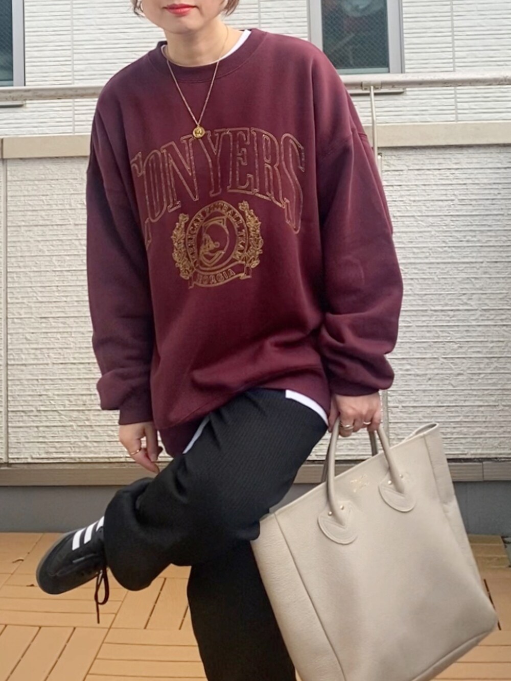 レッド系のスウェット、ブラック系のその他パンツ、ベージュ系のトートバッグを着用したレディースの秋コーディネートの5枚目の写真