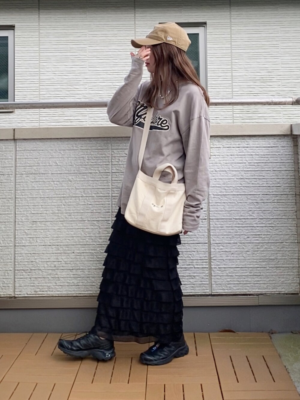 グレー系のTシャツ/カットソー、ブラック系のスカート、ホワイト系のトートバッグを着用したレディースの春コーディネートの2枚目の写真