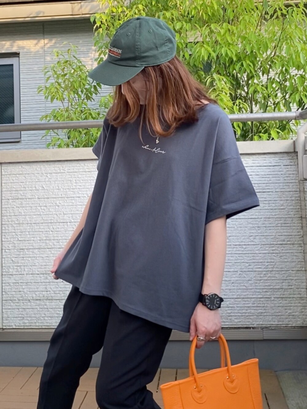 グレー系のTシャツ/カットソー、ブラック系のその他パンツ、オレンジ系のトートバッグを着用したレディースの春コーディネートの4枚目の写真