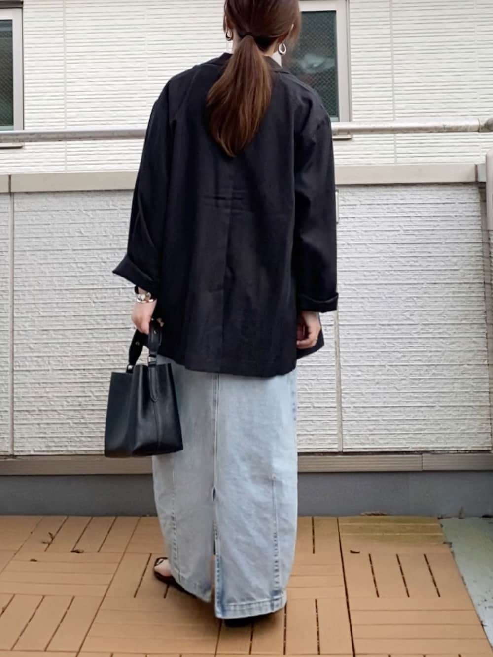 ブラック系のショルダーバッグ、ブラック系のテーラードジャケット、ブラック系のTシャツ/カットソーを着用したレディースの秋コーディネートの3枚目の写真