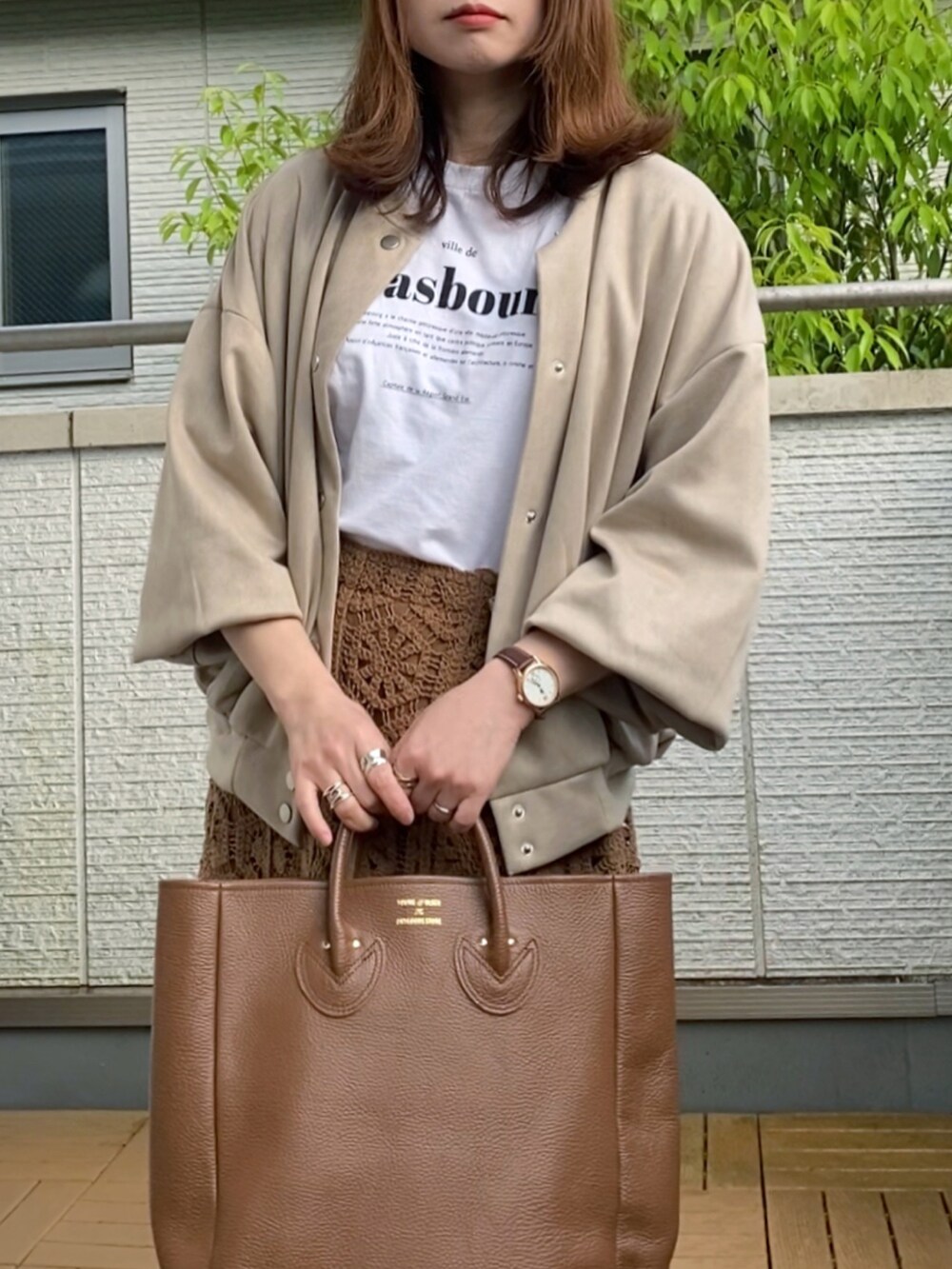 ベージュ系のスタジャン、ホワイト系のTシャツ/カットソー、ブラウン系のスカートを着用したレディースの春コーディネートの3枚目の写真