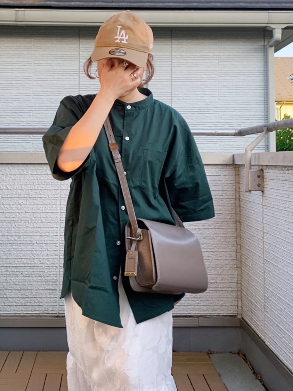 グリーン系のシャツ/ブラウス、ホワイト系のスカート、ホワイト系のスニーカーを着用したレディースの夏コーディネートの5枚目の写真