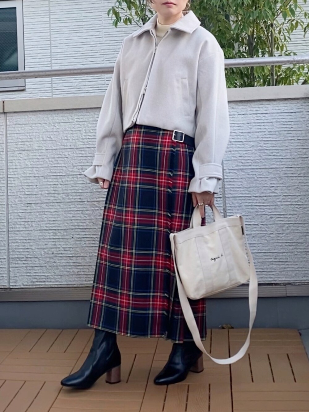 ホワイト系のブルゾン、ブラック系のスカート、ホワイト系のトートバッグを着用したレディースの秋コーディネートの2枚目の写真