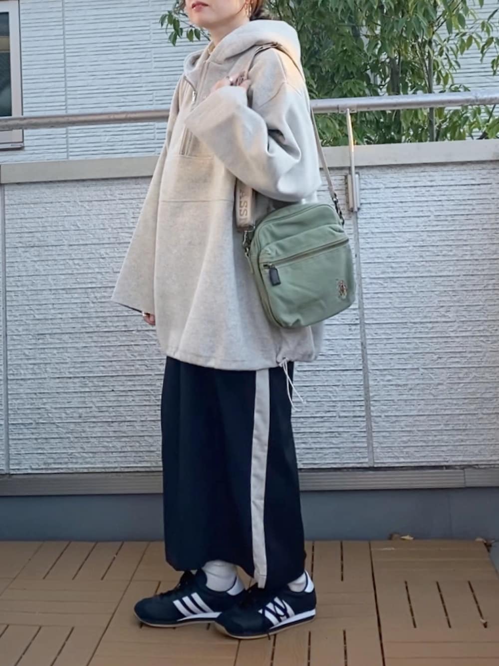 ホワイト系のパーカー、ホワイト系のTシャツ/カットソー、ブラック系のスカートを着用したレディースの冬コーディネートの2枚目の写真