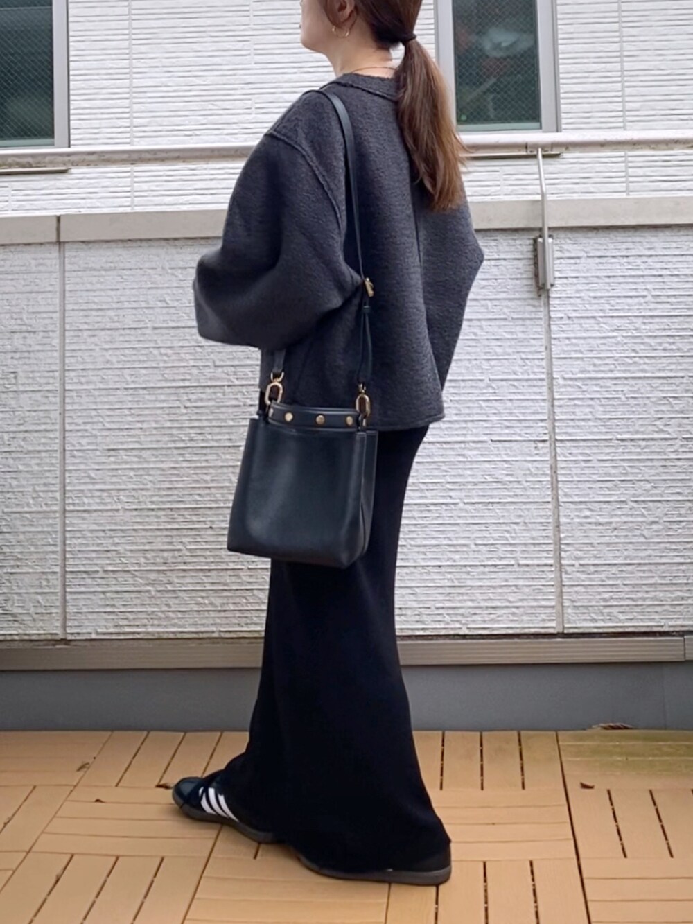グレー系のカーディガン/ボレロ、ブラック系のワンピース、ブラック系のショルダーバッグを着用したレディースの秋コーディネートの3枚目の写真