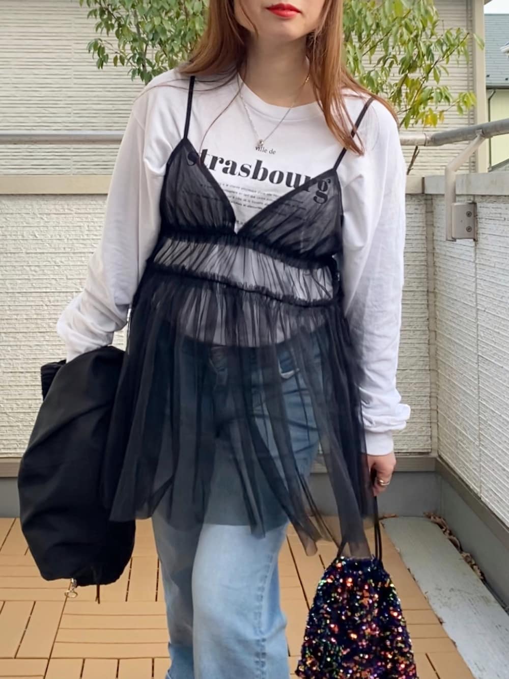 ブラック系のキャミソール、ホワイト系のTシャツ/カットソー、ブラック系のナイロンジャケットを着用したレディースの春コーディネートの4枚目の写真