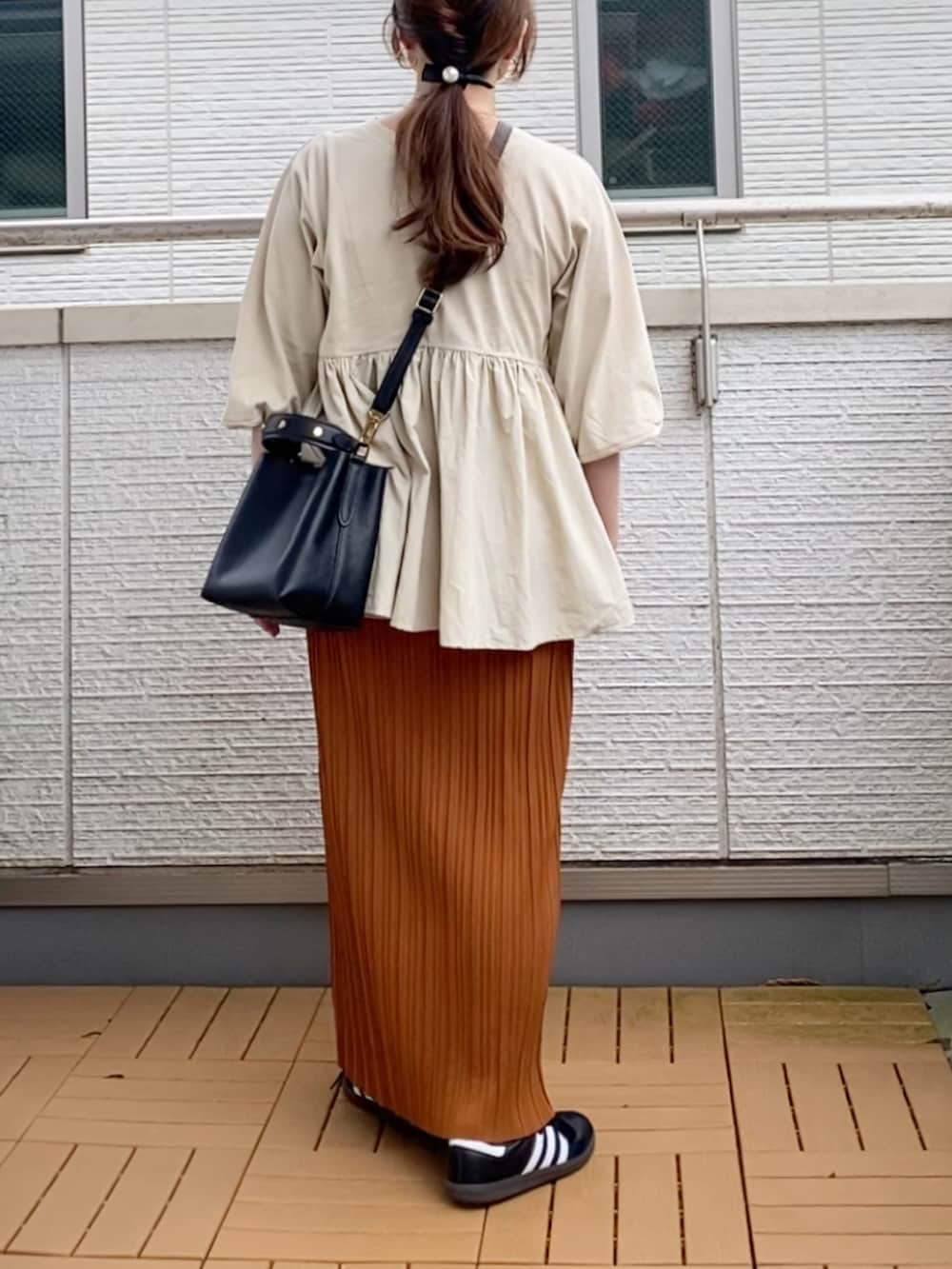 ベージュ系のその他トップス、ブラウン系のスカート、ブラック系のショルダーバッグを着用したレディースの秋コーディネートの2枚目の写真