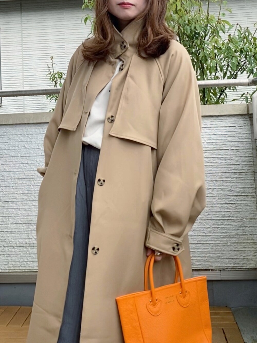 ベージュ系のトレンチコート、ホワイト系のスウェット、グレー系のスラックスを着用したレディースの春コーディネートの4枚目の写真