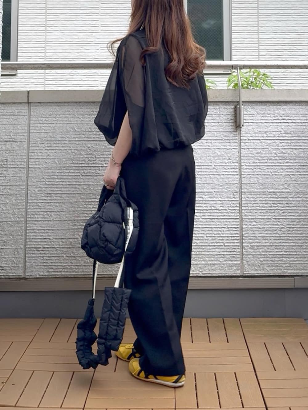 ブラック系のシャツ/ブラウス、ブラック系のスラックス、ブラック系のショルダーバッグを着用したレディースの夏コーディネートの3枚目の写真