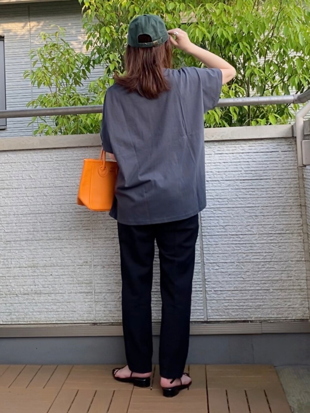グレー系のTシャツ/カットソー、ブラック系のその他パンツ、オレンジ系のトートバッグを着用したレディースの春コーディネートの3枚目の写真