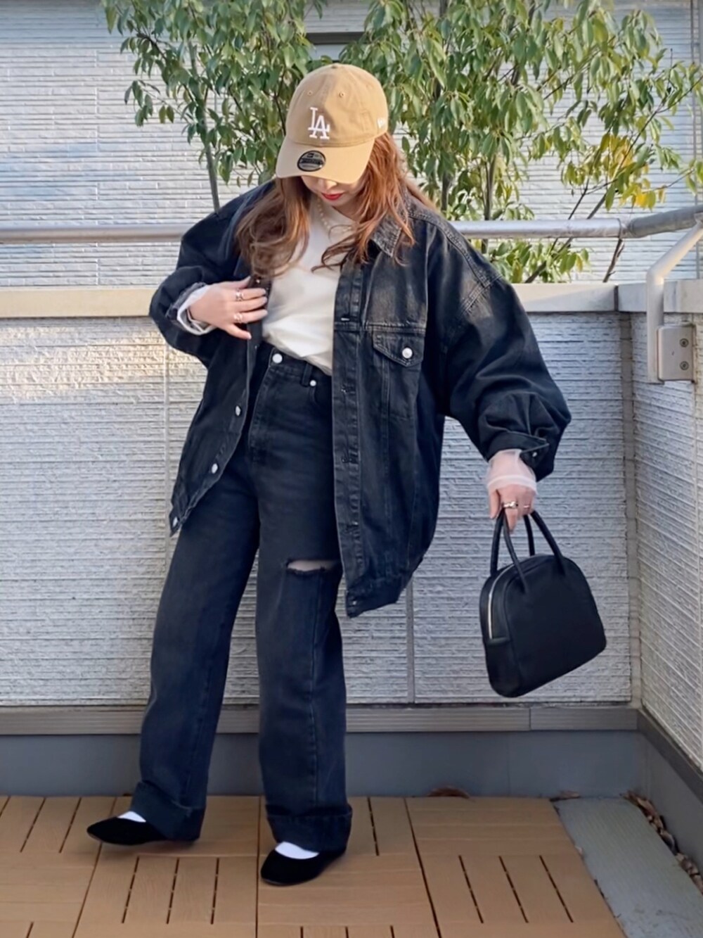 ブラック系のデニムジャケット、ホワイト系のTシャツ/カットソー、ブラック系のデニムパンツを着用したレディースの春コーディネートの3枚目の写真