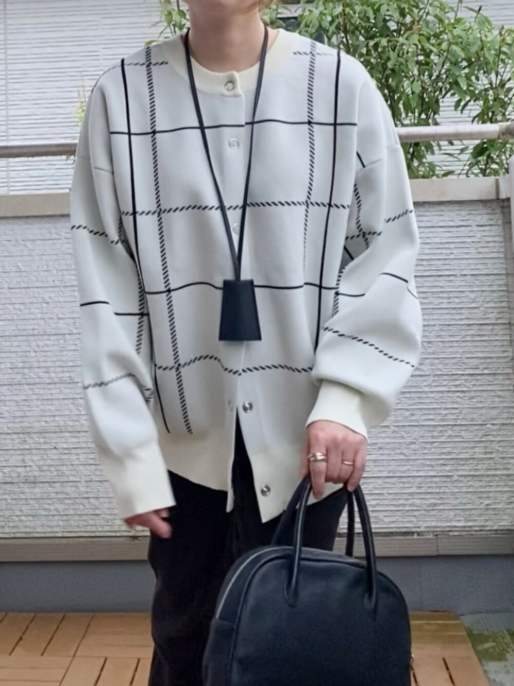 ホワイト系のカーディガン/ボレロ、ブラック系のその他パンツ、ブラック系のショルダーバッグを着用したレディースの秋コーディネートの2枚目の写真