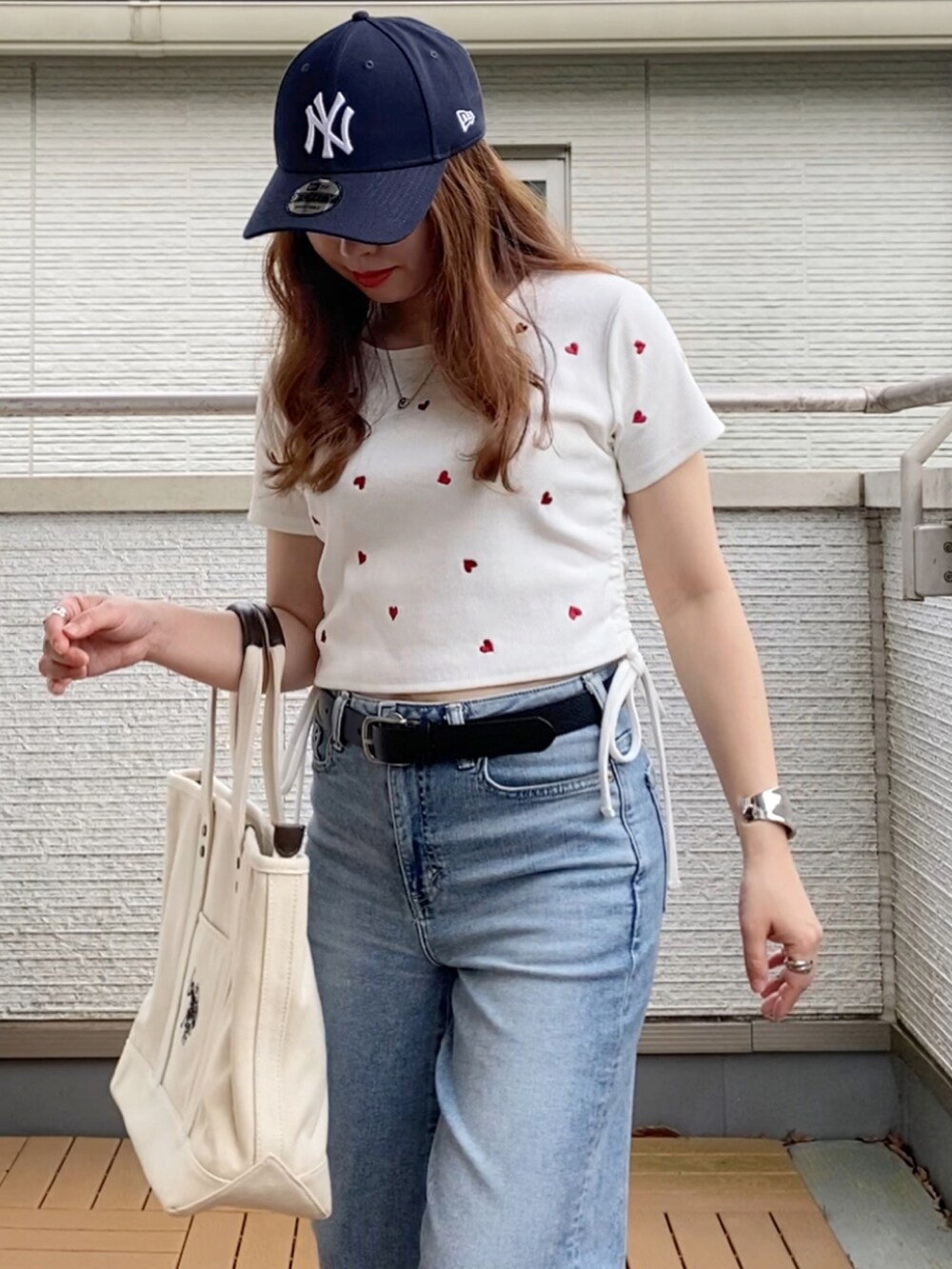 ホワイト系のTシャツ/カットソー、ブルー系のデニムパンツ、ホワイト系のトートバッグを着用したレディースの夏コーディネートの4枚目の写真