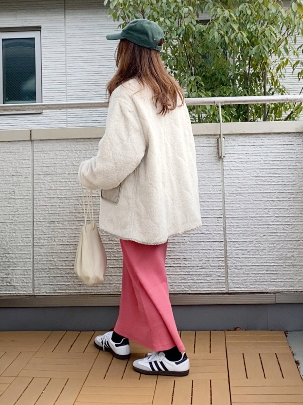 ベージュ系のブルゾン、グレー系のスウェット、ピンク系のスカートを着用したレディースの冬コーディネートの2枚目の写真