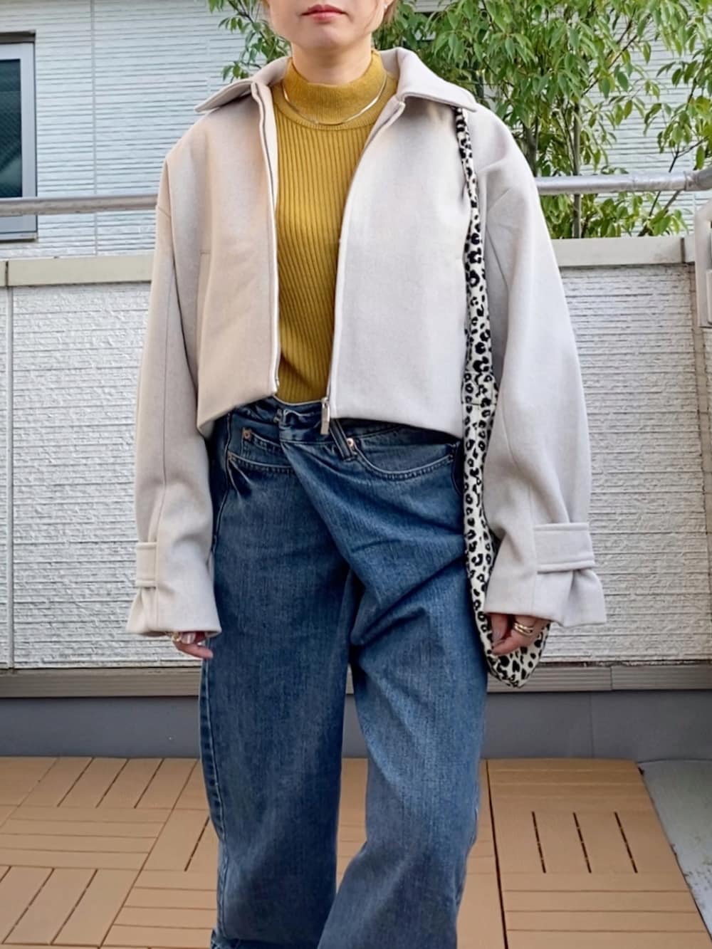 ホワイト系のブルゾン、イエロー系のニット/セーター、ホワイト系のトートバッグを着用したレディースの秋コーディネートの4枚目の写真