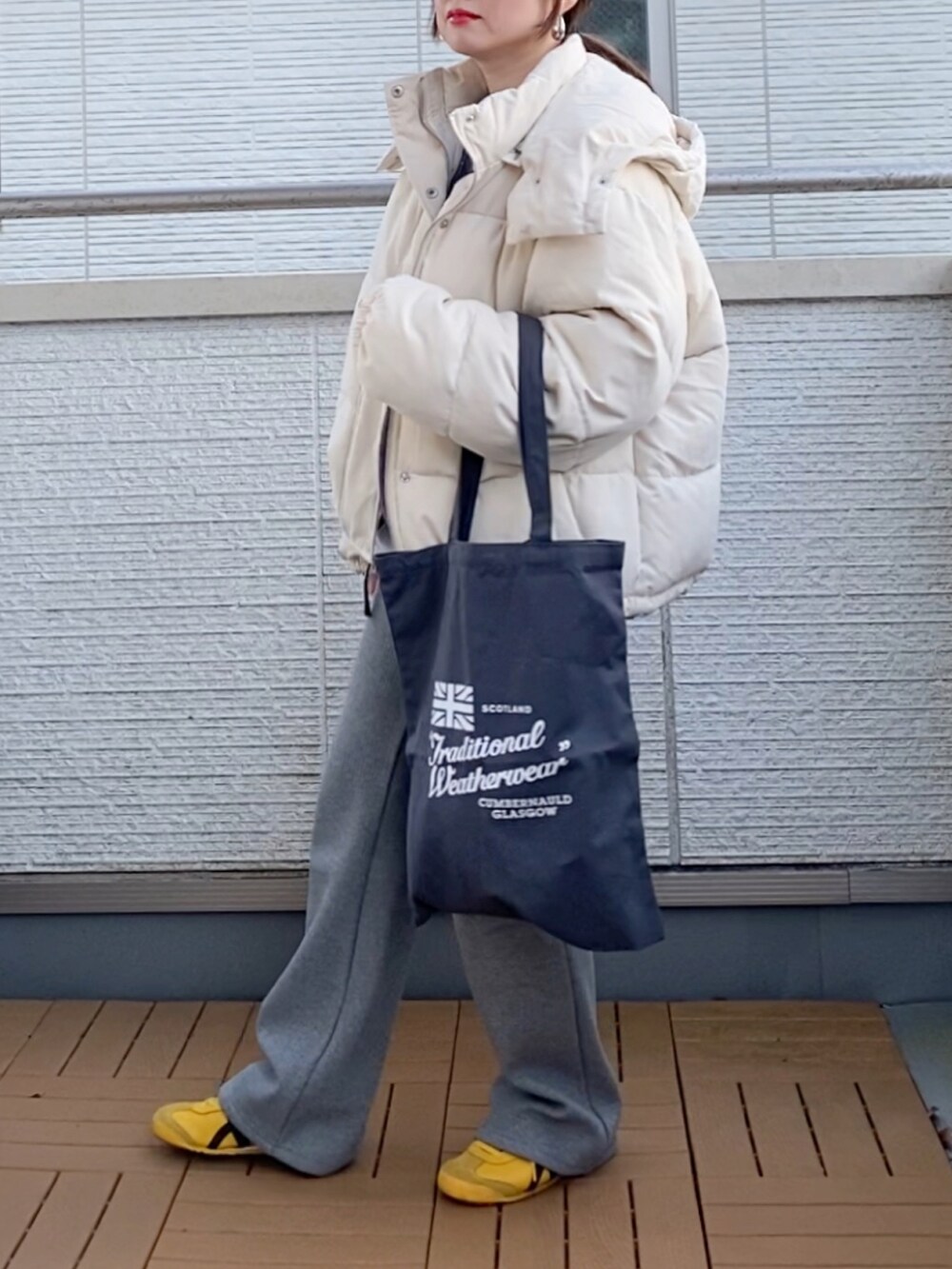 ホワイト系のダウンジャケット/コート、グレー系のニット/セーター、グレー系のその他パンツを着用したレディースの冬コーディネートの3枚目の写真