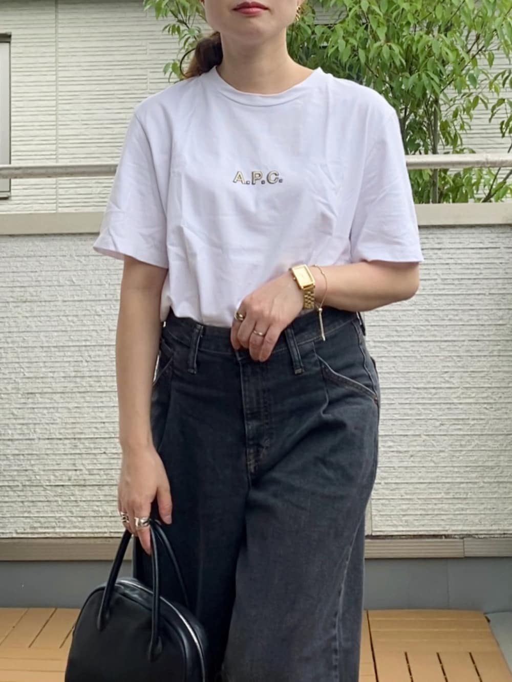 イエロー系のTシャツ/カットソー、ブラック系のデニムパンツ、ブラック系のショルダーバッグを着用したレディースの秋コーディネートの4枚目の写真