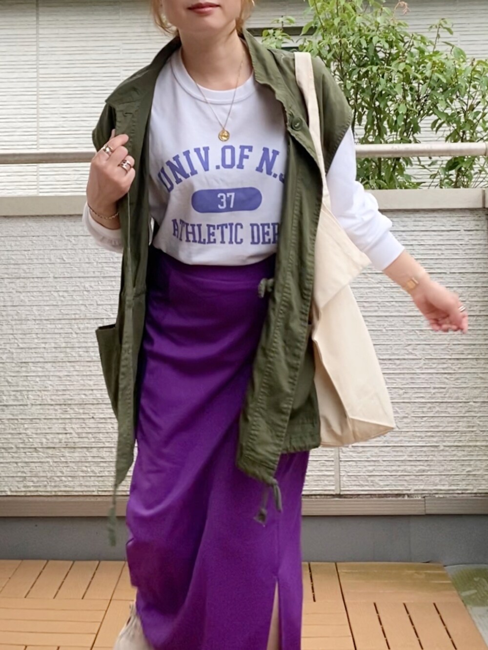 ホワイト系のTシャツ/カットソー、グリーン系のベスト、パープル系のスカートを着用したレディースの夏コーディネートの2枚目の写真