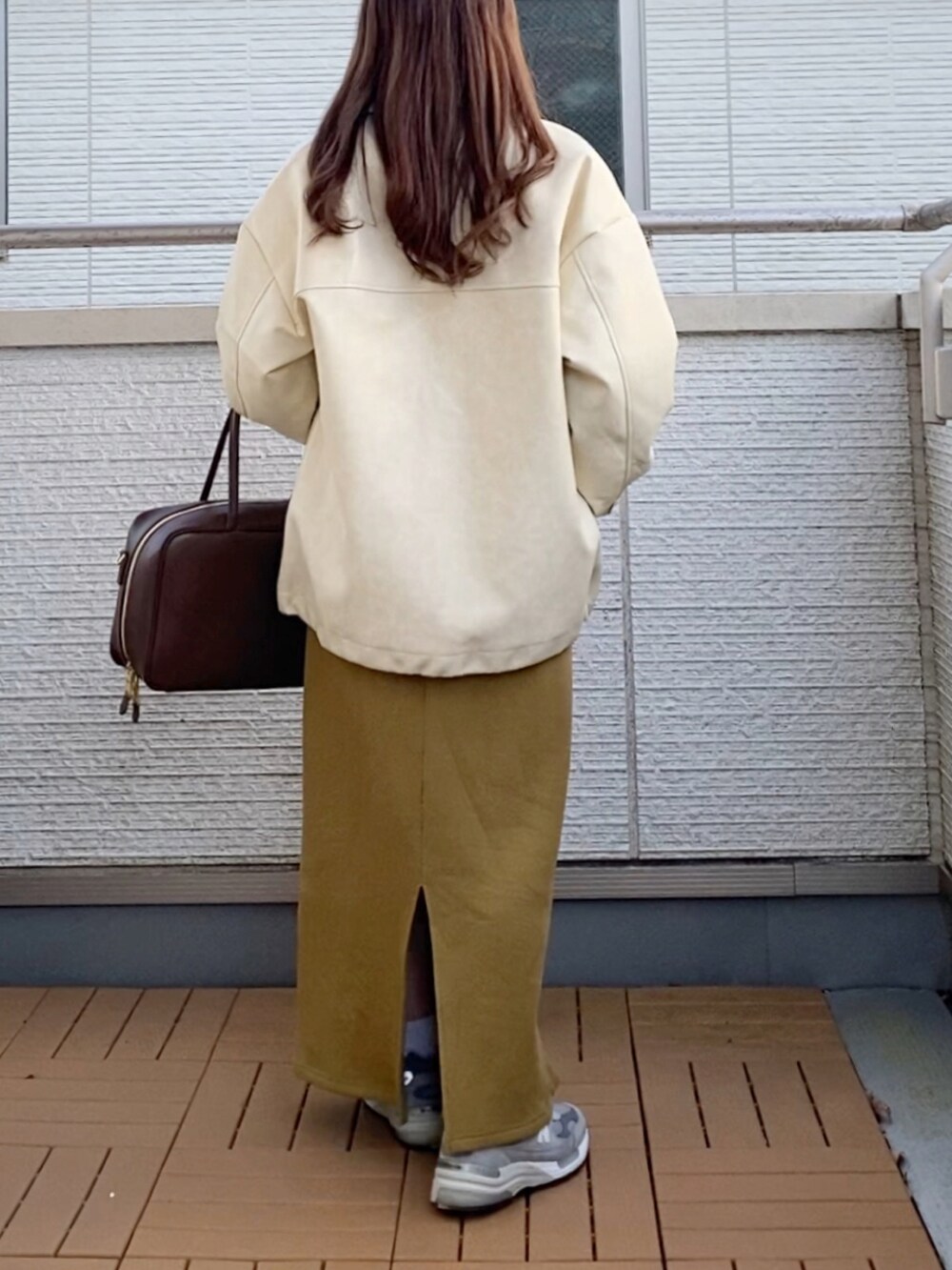 ホワイト系のブルゾン、ホワイト系のニット/セーター、グリーン系のスカートを着用したレディースの冬コーディネートの3枚目の写真