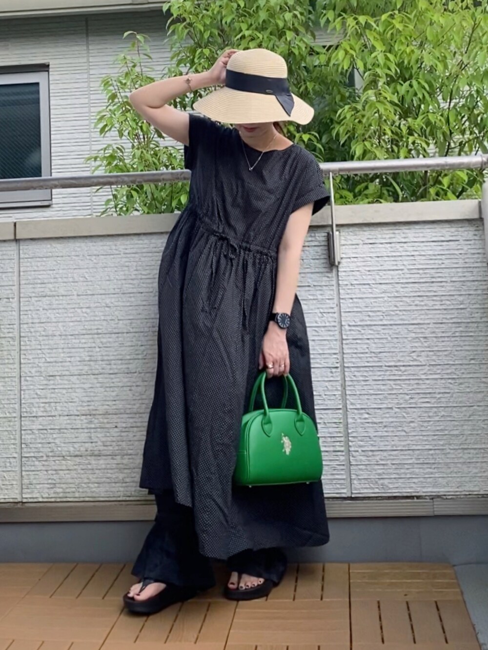 ブラック系のワンピース、ブラック系のその他パンツ、グリーン系のハンドバッグを着用したレディースの夏コーディネートの2枚目の写真