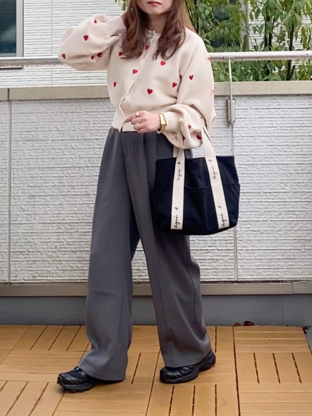 ホワイト系のカーディガン/ボレロ、グレー系のスラックス、ブラック系のトートバッグを着用したレディースの冬コーディネートの2枚目の写真