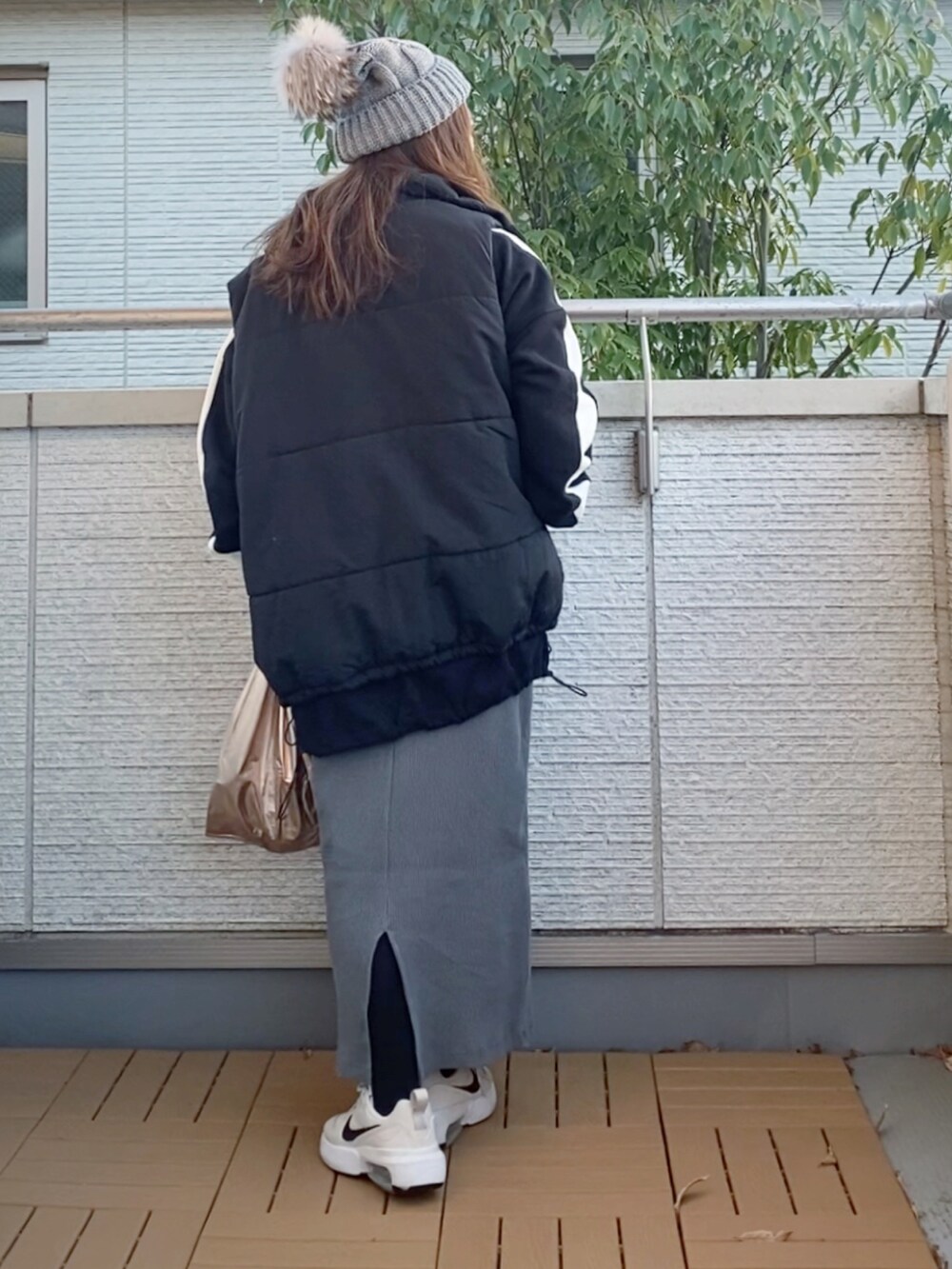 ブラック系のスウェット、ブラック系のベスト、グレー系のスカートを着用したレディースの冬コーディネートの3枚目の写真