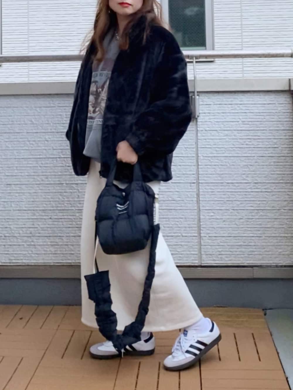 ブラック系のブルゾン、グレー系のスウェット、ホワイト系のスカートを着用したレディースの秋コーディネートの2枚目の写真