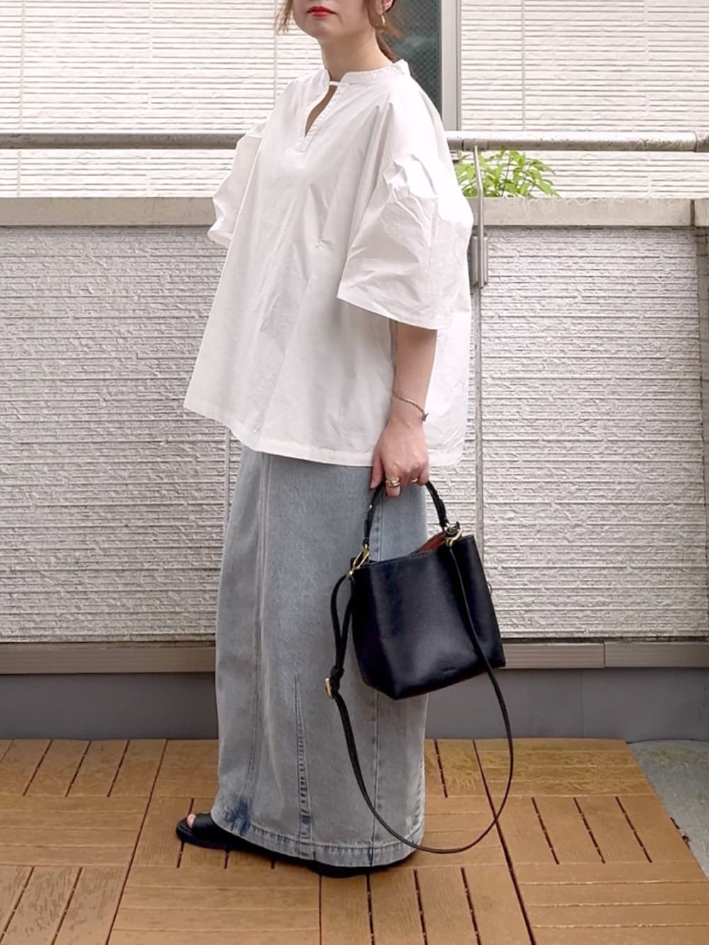 ホワイト系のシャツ/ブラウス、ブルー系のデニムスカート、ブラック系のショルダーバッグを着用したレディースの夏コーディネートの3枚目の写真