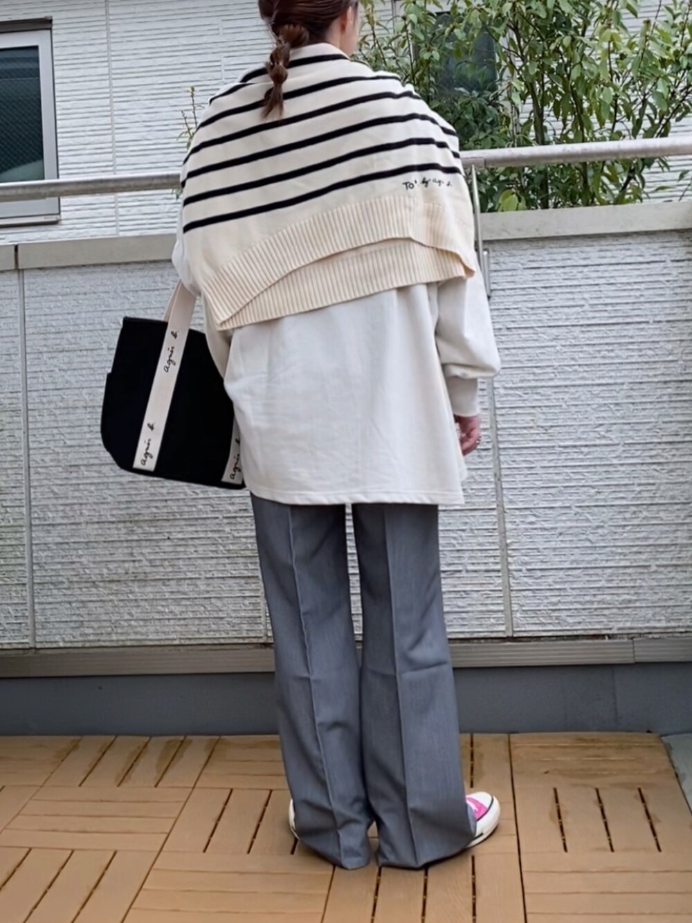 ホワイト系のスウェット、ホワイト系のニット/セーター、グレー系のスラックスを着用したレディースの春コーディネートの2枚目の写真