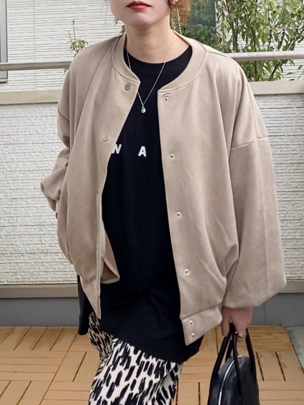 ベージュ系のスタジャン、ブラック系のTシャツ/カットソー、ホワイト系のその他パンツを着用したレディースの春コーディネートの3枚目の写真