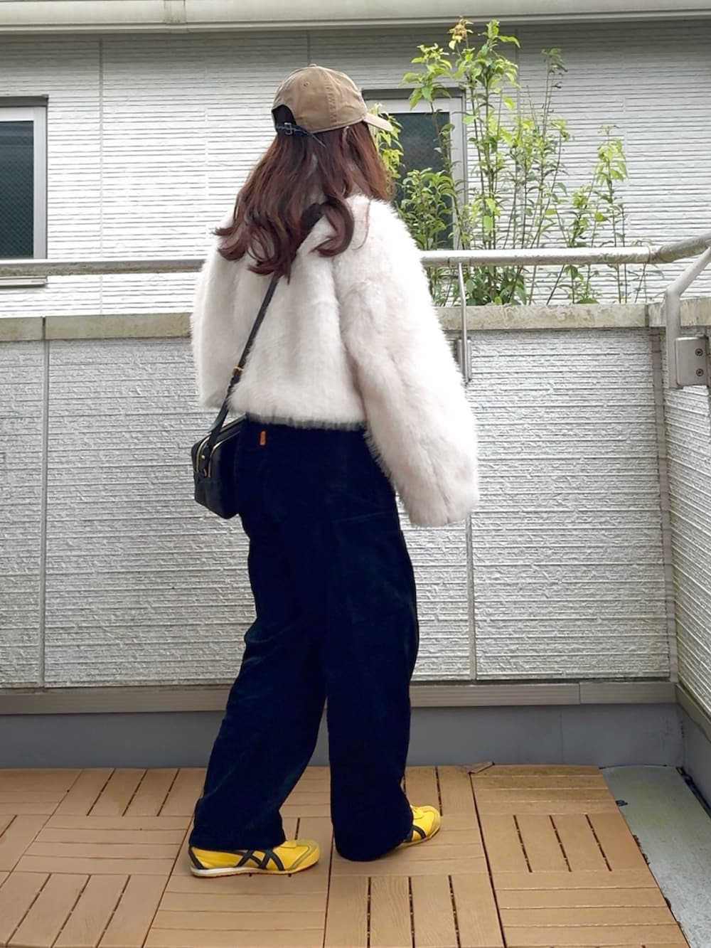 ホワイト系のブルゾン、ブラック系のその他パンツ、イエロー系のスニーカーを着用したレディースの秋コーディネートの4枚目の写真