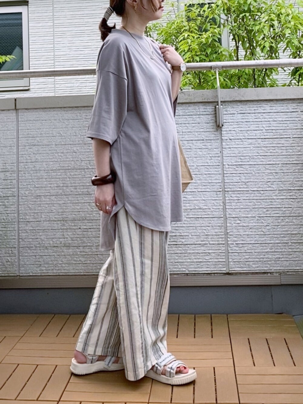 ベージュ系のTシャツ/カットソー、ホワイト系のその他パンツ、ベージュ系のエコバッグ/サブバッグを着用したレディースの夏コーディネートの2枚目の写真